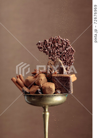 Various chocolates with ingredients in an old brass bowl. Various chocolates with ingredients in an old brass bowl. 72676969
