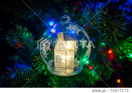 Russia. Saint-Petersburg. Christmas decoration for Christmas tree snow glowing fairy house in a glass bowl. 72677173