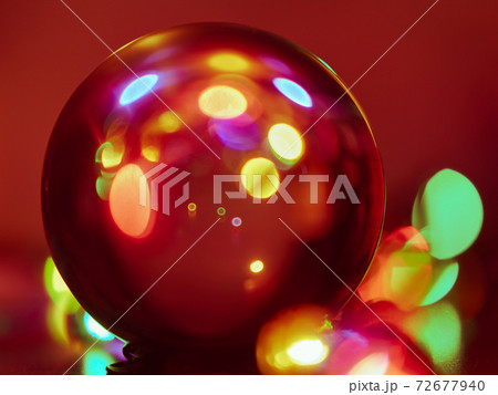Festive photography. Holidays composition. Rosebud crystal candlestick in front of the clear crystal ball. Red Miracle Christmas. Concepts of Christmas Eve and home party. Natural background 72677940