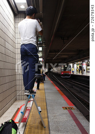 駅ホームで脚立を使用するカメラマン 72679343