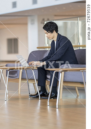 ノートパソコンで作業をする若いビジネスマン 72679539