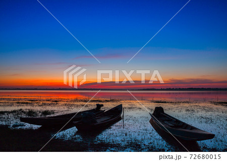 longboat on colorful sky reflect on water in dam 72680015