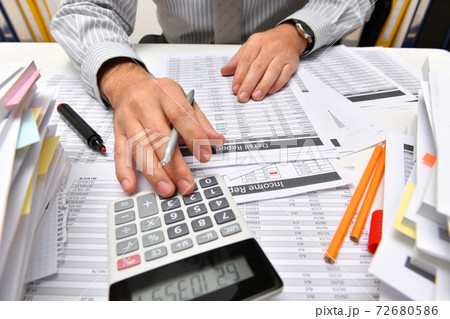 business concept - businessman working with reports in office, table and workspace close view, analyzing financial data, writes and counts business concept - businessman working with reports in office, table and workspace close view, analyzing financial data, writes and counts 72680586