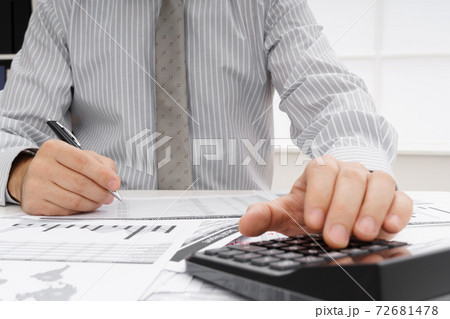 business concept - businessman's working table close view, checks financial reports, writes and counts business concept - businessman's working table close view, checks financial reports, writes and counts 72681478