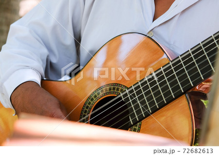 Man playing an acoustic guitar  72682613