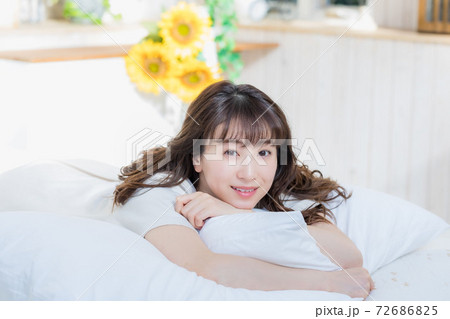 ベッドに寝そべってリラックスする女性 ベッドに寝そべってリラックスする女性 72686825