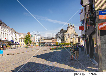 Mechelen, Flanders, Belgium. August 2019. In the background the facade of the church of Sint-Pieter-en-Pauluskerk. Beautiful summer day, people are walking. 72687393