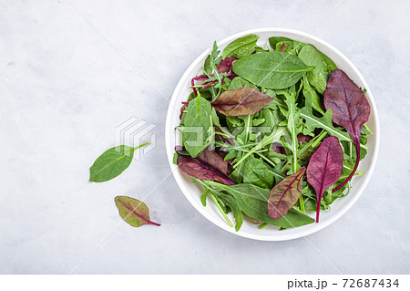Healthy salad, leaves mix salad of spinach, arugula, lettuce in white plate on grey table . 72687434