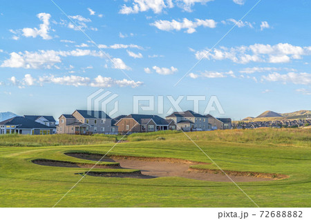 Golf course and houses with distant mountain and blue sky view on a sunny day 72688882