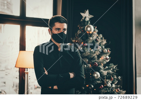 Portrait of a brunette in a black shirt in a black face mask. Black face mask during the pandemic corona virus. Portrait of a brunette in a black shirt in a black face mask. Black face mask during the pandemic corona virus. 72689229