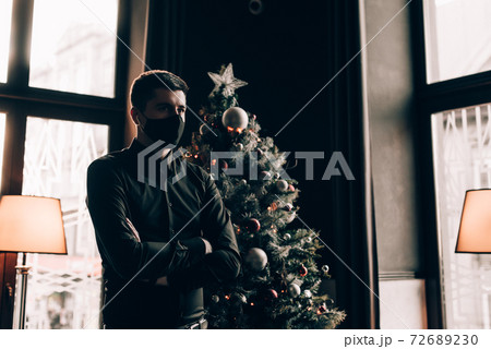 Portrait of a brunette in a black shirt in a black face mask. Black face mask during the pandemic corona virus. Portrait of a brunette in a black shirt in a black face mask. Black face mask during the pandemic corona virus. 72689230