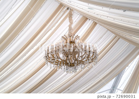 Beautiful chandelier with crystals and faux candles at a wedding venue Beautiful chandelier with crystals and faux candles at a wedding venue 72690031