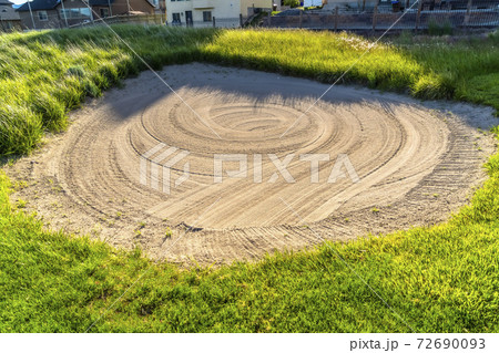 Close up of a sand trap surrounded by grasses at a golf course on a sunny day Close up of a sand trap surrounded by grasses at a golf course on a sunny day 72690093
