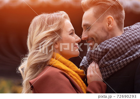 Super close up of kissing young couple. Husband and a wife hugged smile looking at each other in the autumn park. Outdoor shot of a young couple in love 72690293