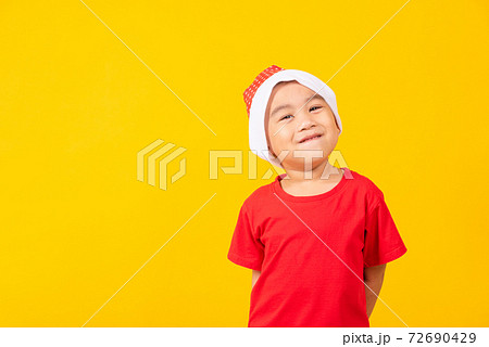 Kid dressed in red Santa Claus hat 72690429