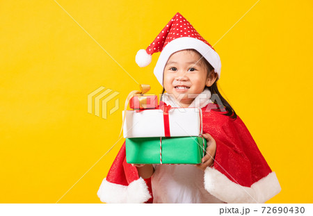Kid dressed in red Santa Claus hat hold gift box on hands 72690430