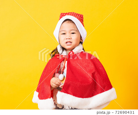 little cute girl smiling, Kid dressed in Santa Claus hat 72690431