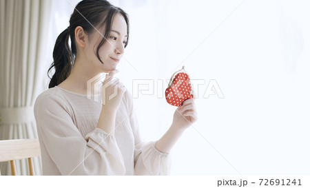 財布を持っている若い女性 72691241