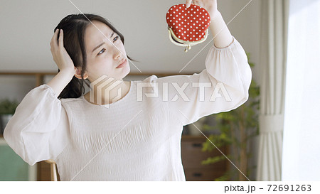 財布を持っている若い女性 72691263