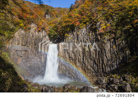 新潟県妙高市 虹の出た紅葉と青空の苗名滝の写真素材