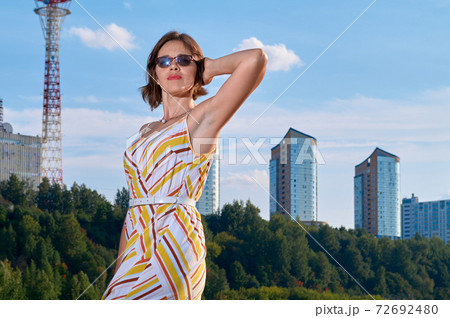 Woman standing in front of cityscape with skyscrapers 72692480