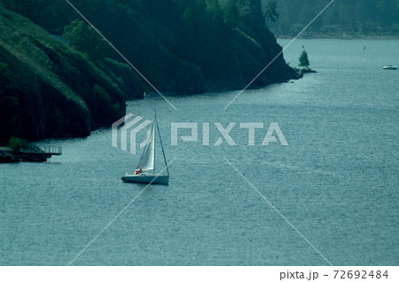 Sailing yacht in the lake against the backdrop of mountains Sailing yacht in the lake against the backdrop of mountains 72692484