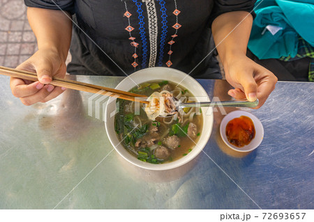 Top view of local woman eating Pho noodle soup Top view of local woman eating Pho noodle soup 72693657