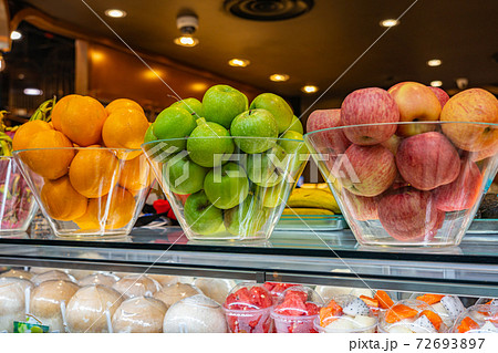 Pile of oranges and apples displayed at juice stall's showcase 72693897