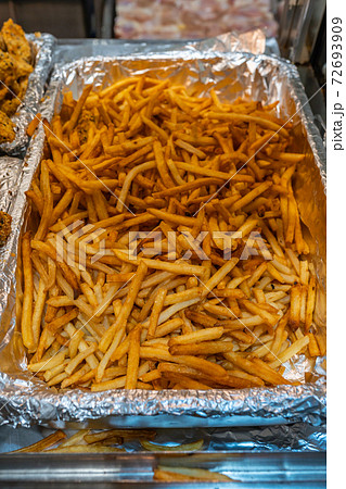 Pile of french fries in aluminum tray at food stall 72693909