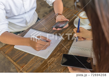 Female and male hands holding phone and writing note 72694208