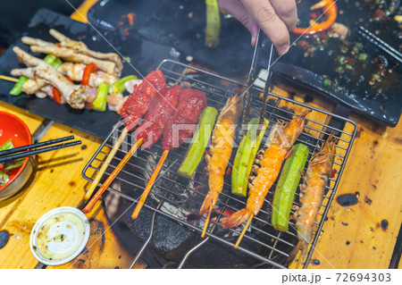 Grilled shrimps and vegetables on BBQ charcoal stove Grilled shrimps and vegetables on BBQ charcoal stove 72694303