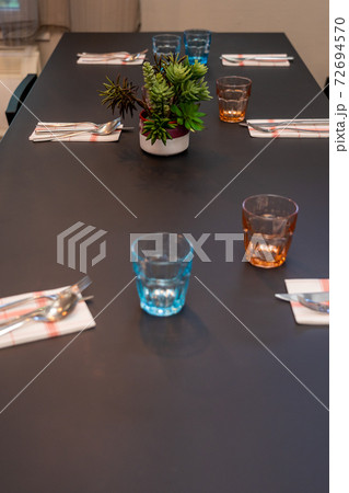 Black wooden dinning table and colorful glasses prepared for dinner 72694570
