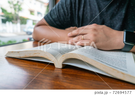 Close up photo of young man reading book indoor 72694577