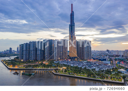 Tall buildings on along riverbank under cloudy sky in evening Tall buildings on along riverbank under cloudy sky in evening 72694660