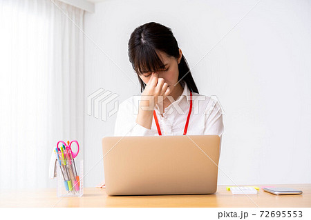 オフィスで目の疲れを感じる若い女性 オフィスで目の疲れを感じる若い女性 72695553