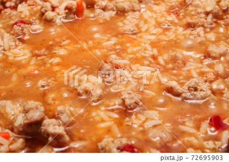 Rice and meat are cooked in a frying pan Rice and meat are cooked in a frying pan 72695903
