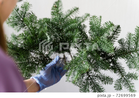 Woman florist doing pine garland for christmas in slow motion. DIY decoration, small business 72699569