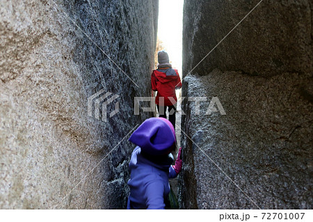 石割山の石割神社の岩の隙間を通る女性登山者 72701007