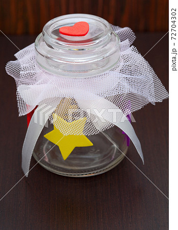 empty jar with a bow on a wooden background empty jar with a bow on a wooden background 72704302