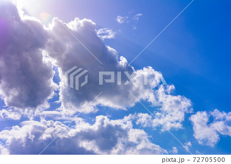 Blue sky and white cumulus clouds, clouds obscure the sun, sunlight can be seen from behind the clouds. 72705500