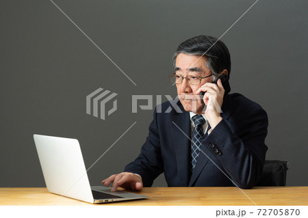 スマートフォンで会話するビジネスマン 72705870