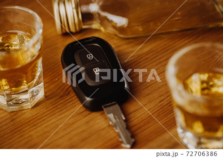 Close up of a car keys and very strong alcohol on the table, do not drink and drive concept 72706386