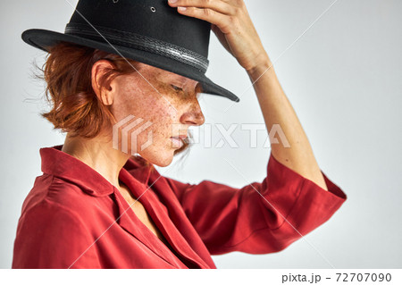 side view freckled woman with short natural red haired in black hat 72707090