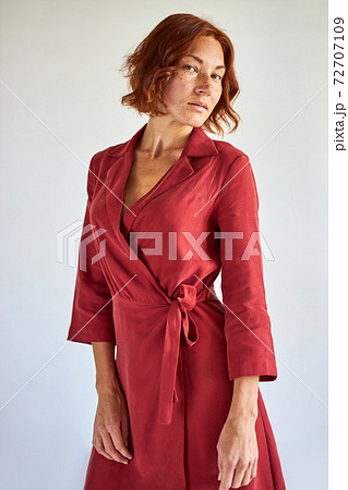 portrait of confident redhead lady in red dress posing portrait of confident redhead lady in red dress posing 72707109