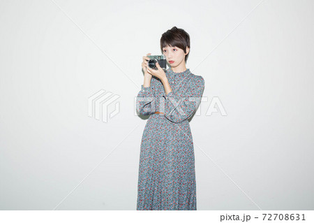 フィルムカメラを持って立つ若い女性 72708631