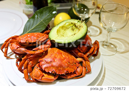 Close-up boiled red crabs, avocado, laurel, wine glasses Close-up boiled red crabs, avocado, laurel, wine glasses 72709672