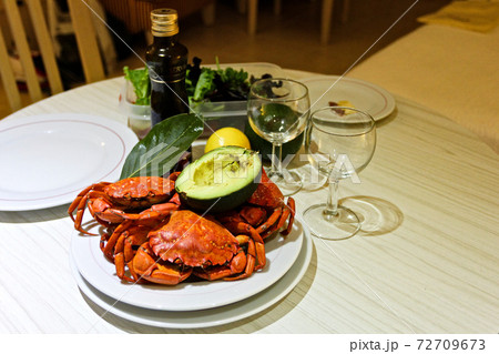 Close-up boiled red crabs, avocado, laurel, wine glasses, olive oil, lettuce 72709673