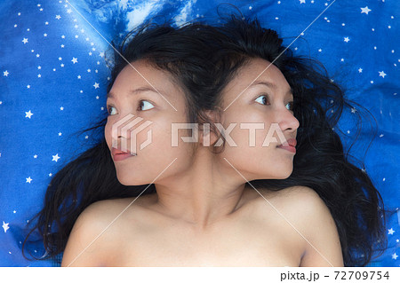 Two-headed woman lying on bed. The woman is obsessed with the evil ghost. Nightmare in bed. Two-headed woman lying on bed. The woman is obsessed with the evil ghost. Nightmare in bed. 72709754