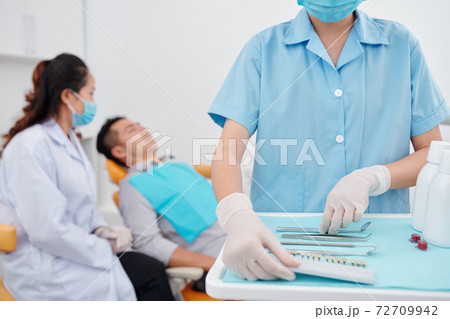 Nurse preparing tools for dentist Nurse preparing tools for dentist 72709942