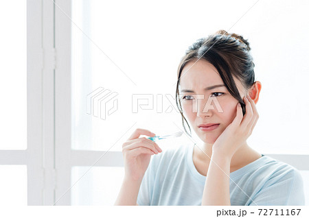 歯に痛みを感じる若い女性 72711167
